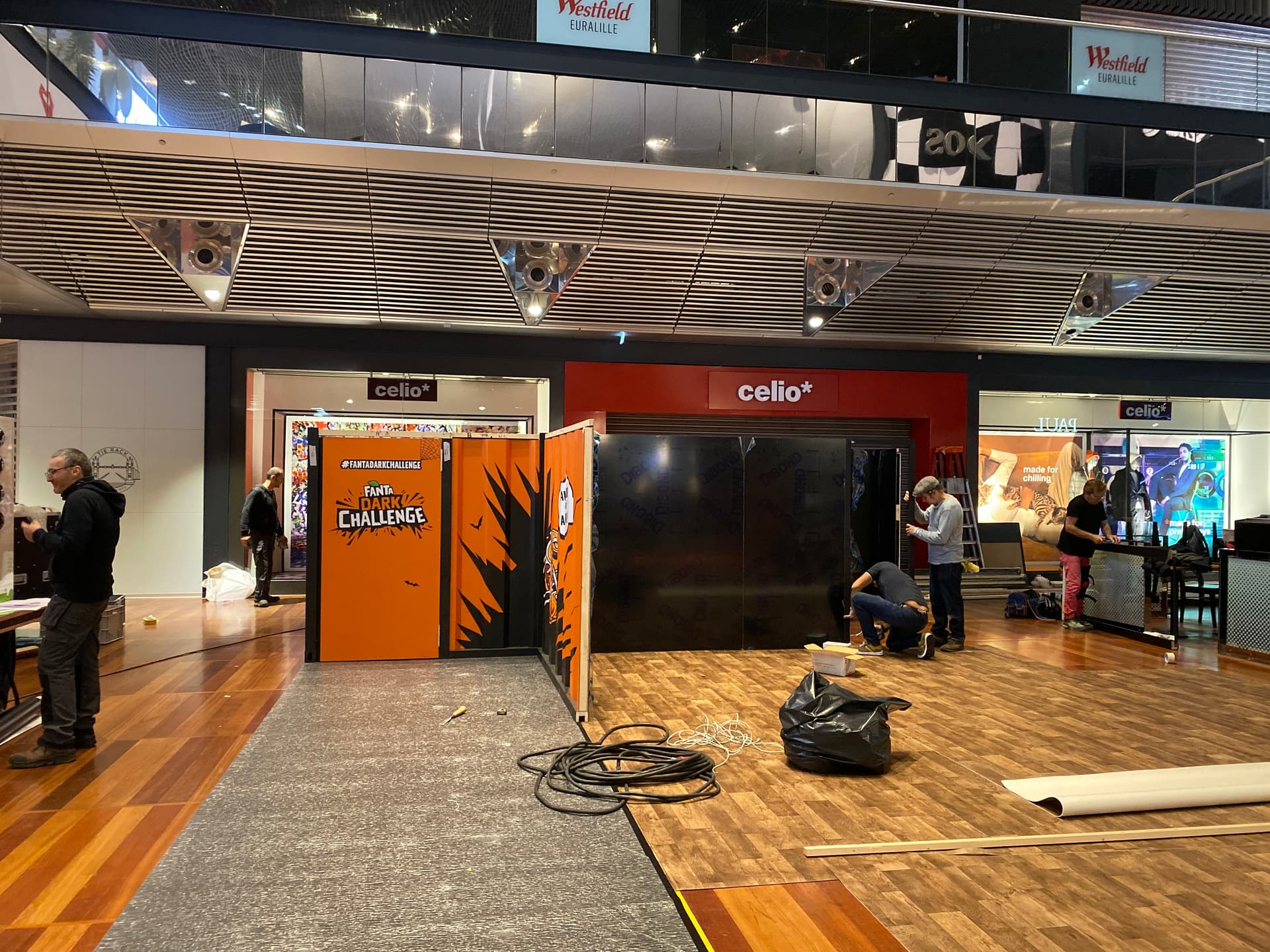 Setup of a modular event structure with graphic partition walls and technical flooring in a shopping mall