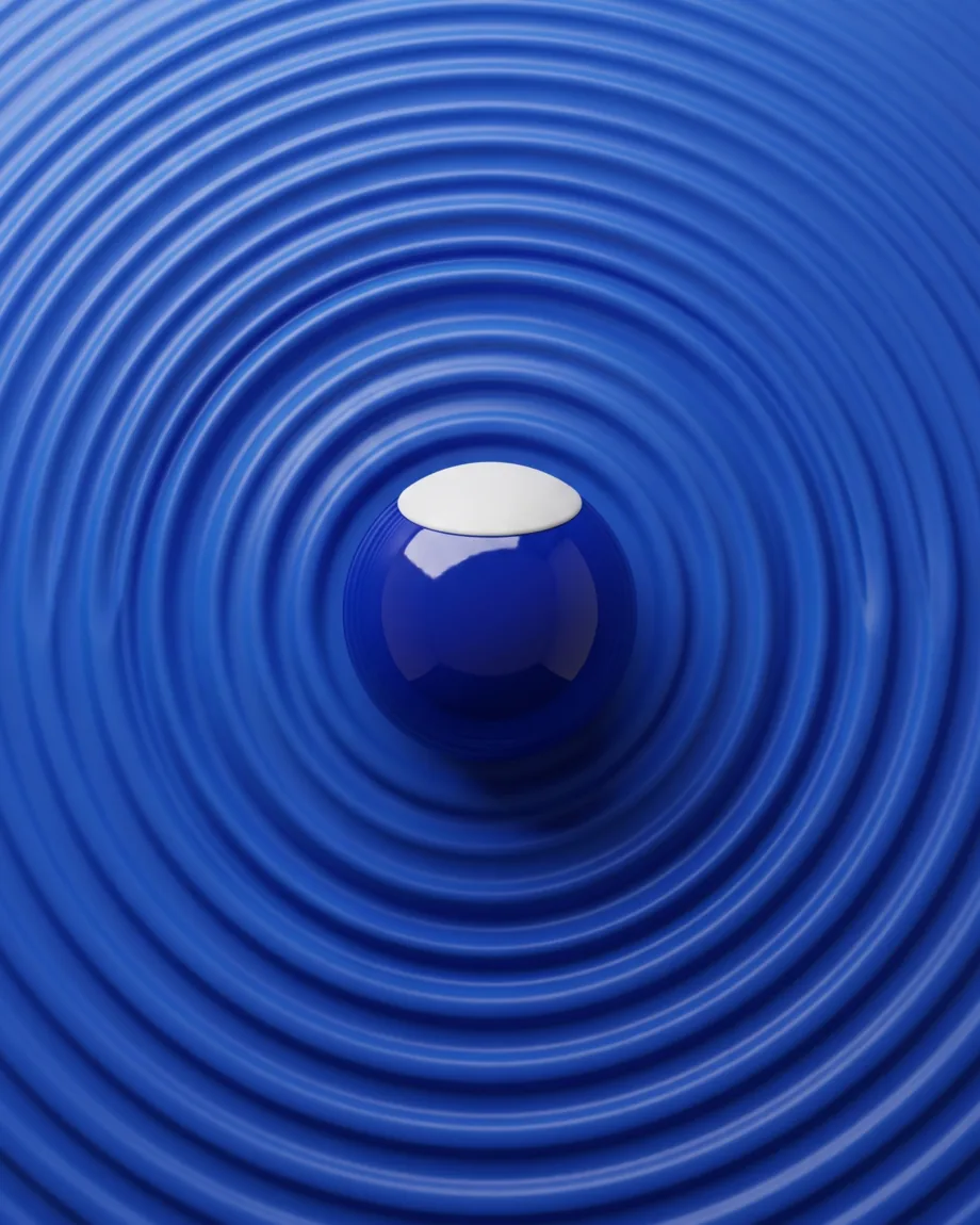 Des ondulations concentriques se propageant sur une surface bleue depuis une bille laquée unique