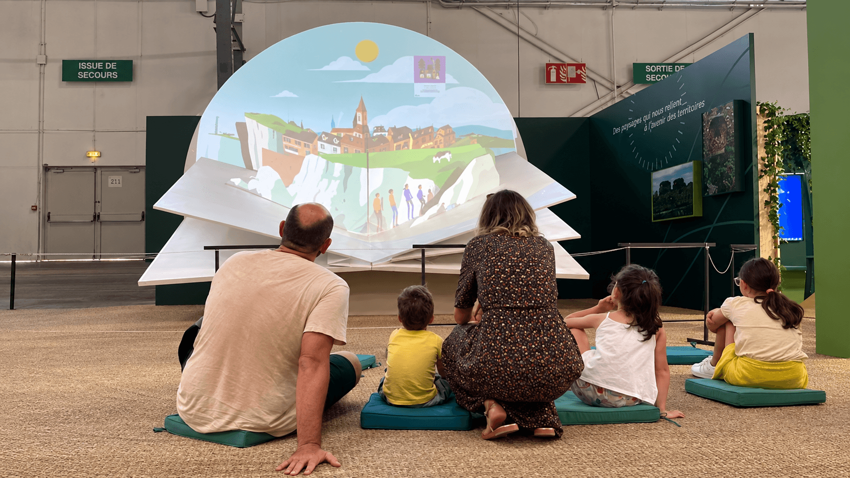 Livre géant en menuiserie avec projection vidéo mapping pour le public d'une exposition événementielle